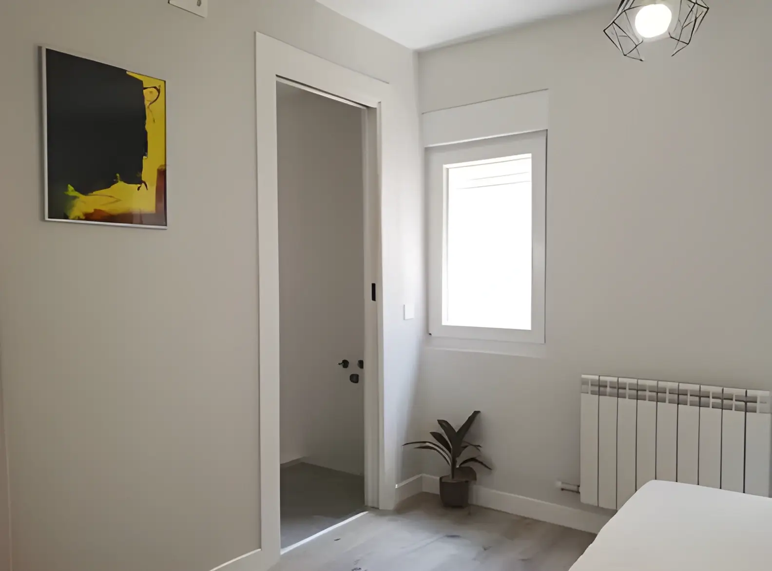 Habitación recién pintada en blanco por Los Pintores Leganés para comunidad de vecinos
