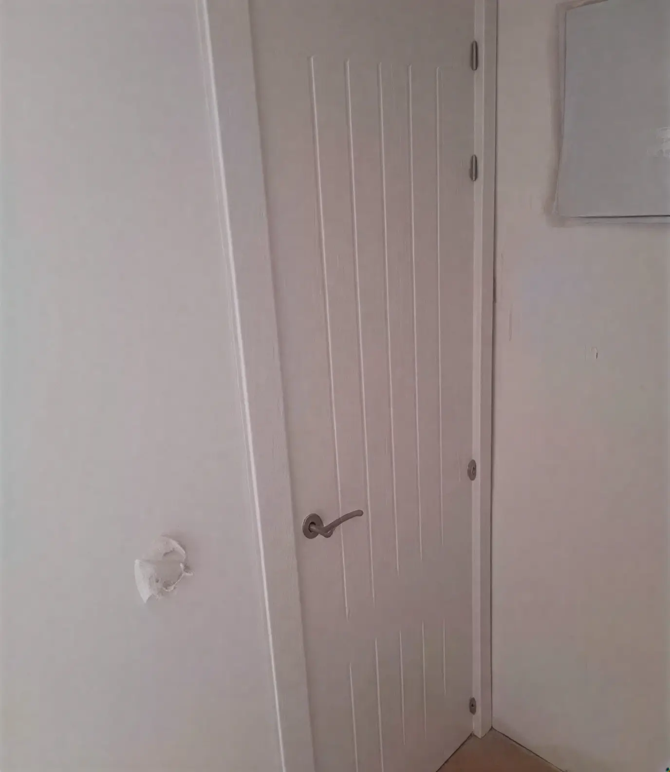 Puerta moderna con ranuras lacada en blanco por pintores profesionales en Leganés